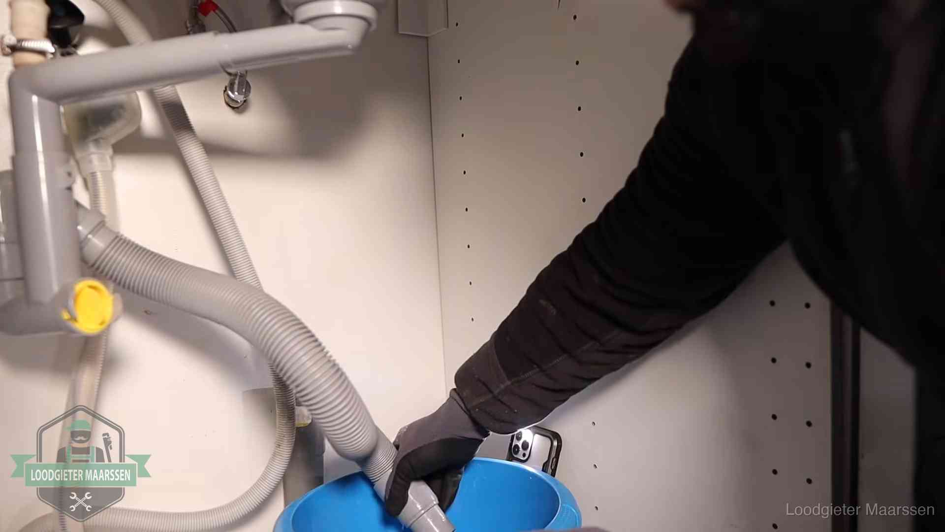 Afvoerslang loopt leeg in een emmer onder de gootsteen in Maarssen, een klus die je zelf kunt doen