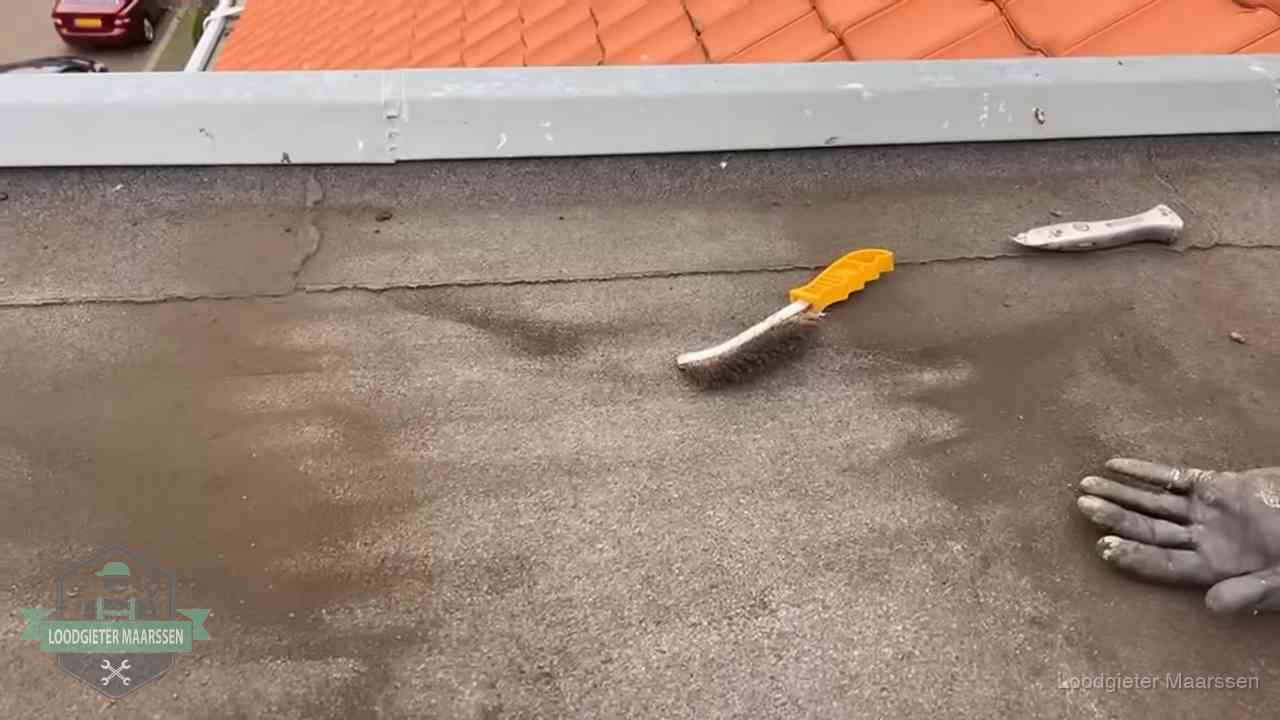 Kosten van daklekkage-reparatie in Maarssen Dakdekker bereidt een bitumen plat dak voor op reparatie bij de daktrim in Maarssen