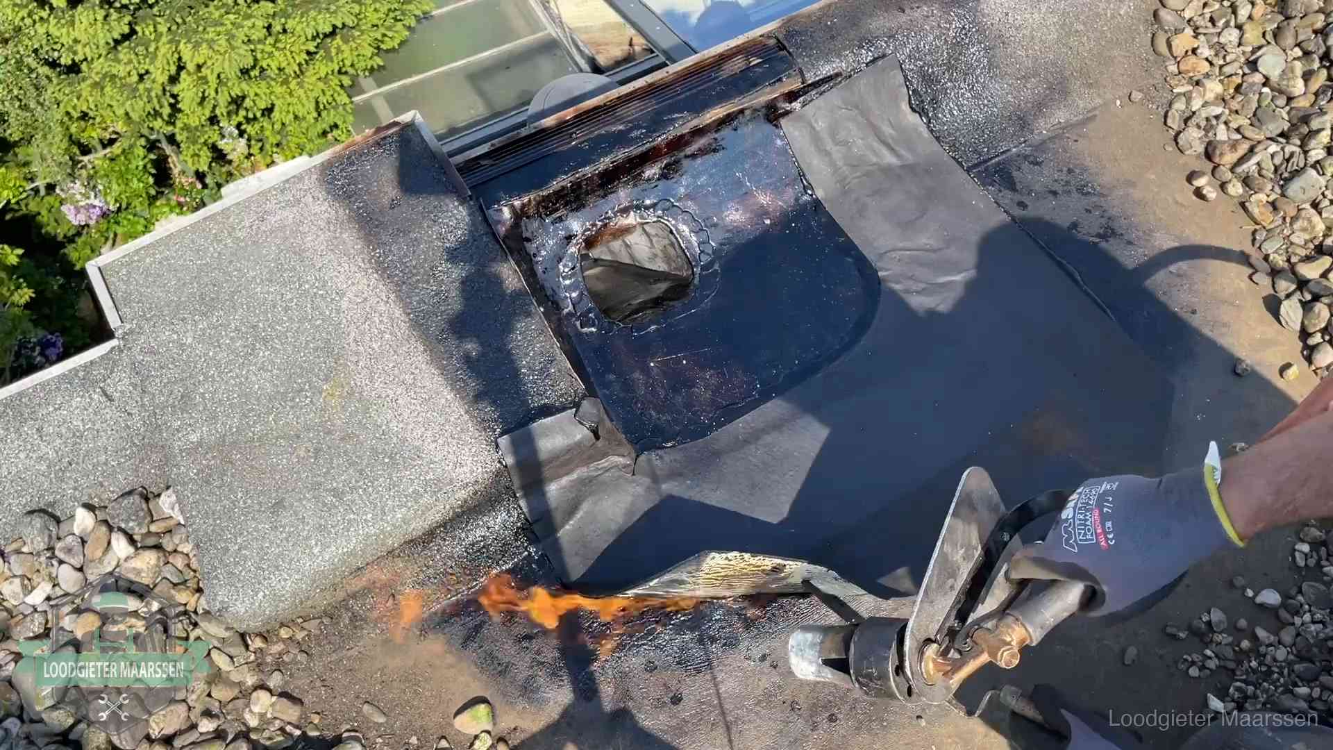 Daklekkage repareren in Maarssen Dakdekker brandt bitumen rond een doorvoer tijdens een daklekkage-reparatie in Maarssen