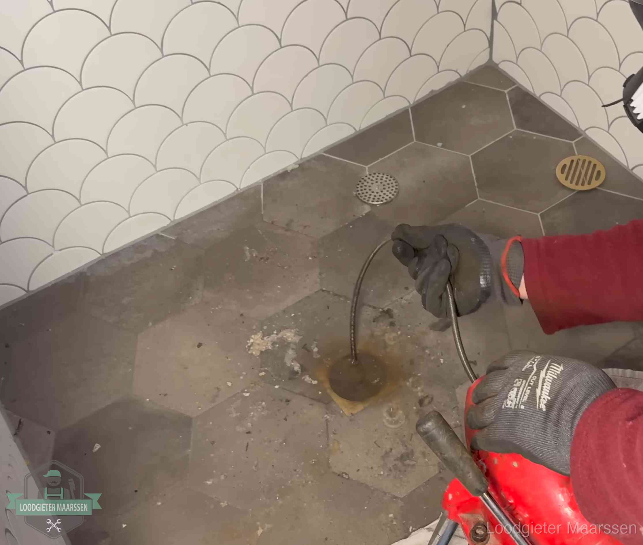 Ontstoppingsveer gaat in een geopend doucheputje in Maarssen waar het water omhoogkwam