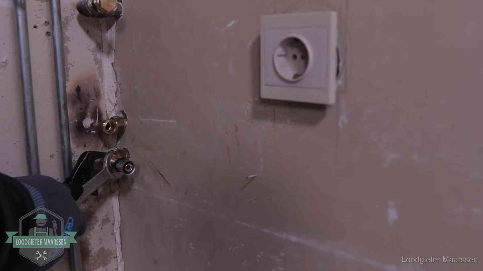 Monteur draait een perskoppeling vast op een leidingaansluiting in Maarssen