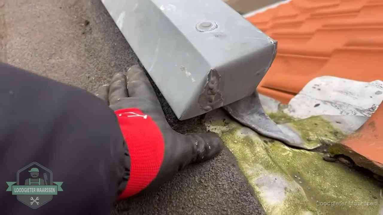 Hemelwaterafvoer en dakgoot controleren in Maarssen Controle van een zinken hemelwaterafvoer met loodslab bij dakpannen in Maarssen