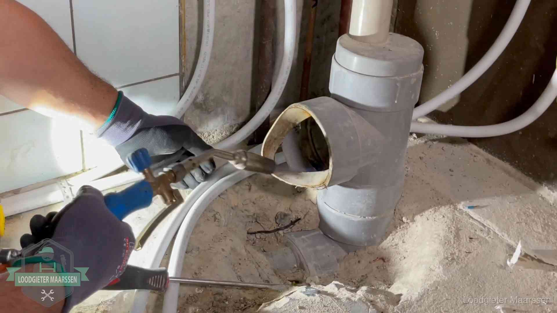 Loodgieter werkt met brander en messing kraanwerk aan leidingen in Maarssen