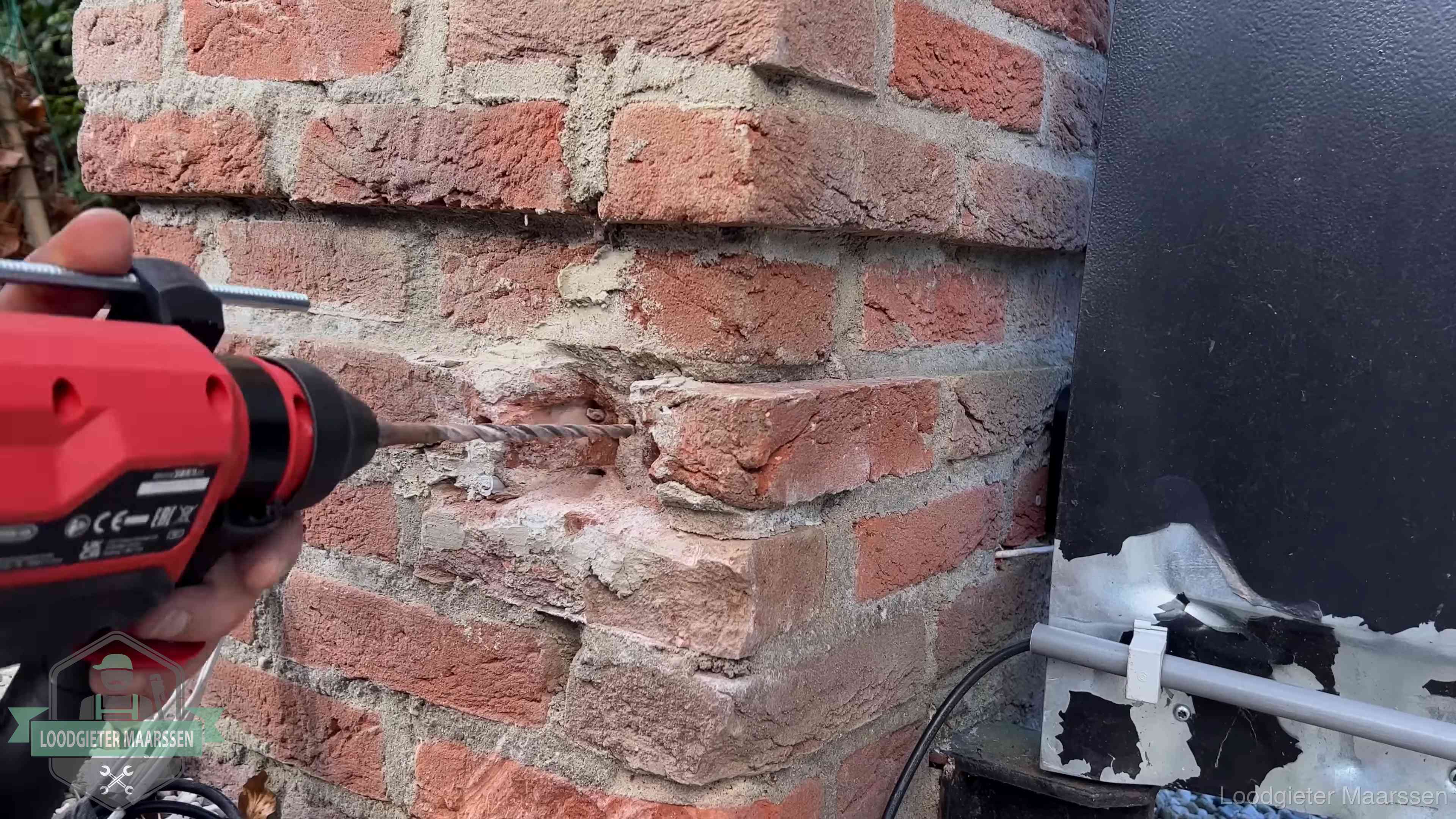 Vakman boort in de buitenmuur van een woning in de regio Maarssen