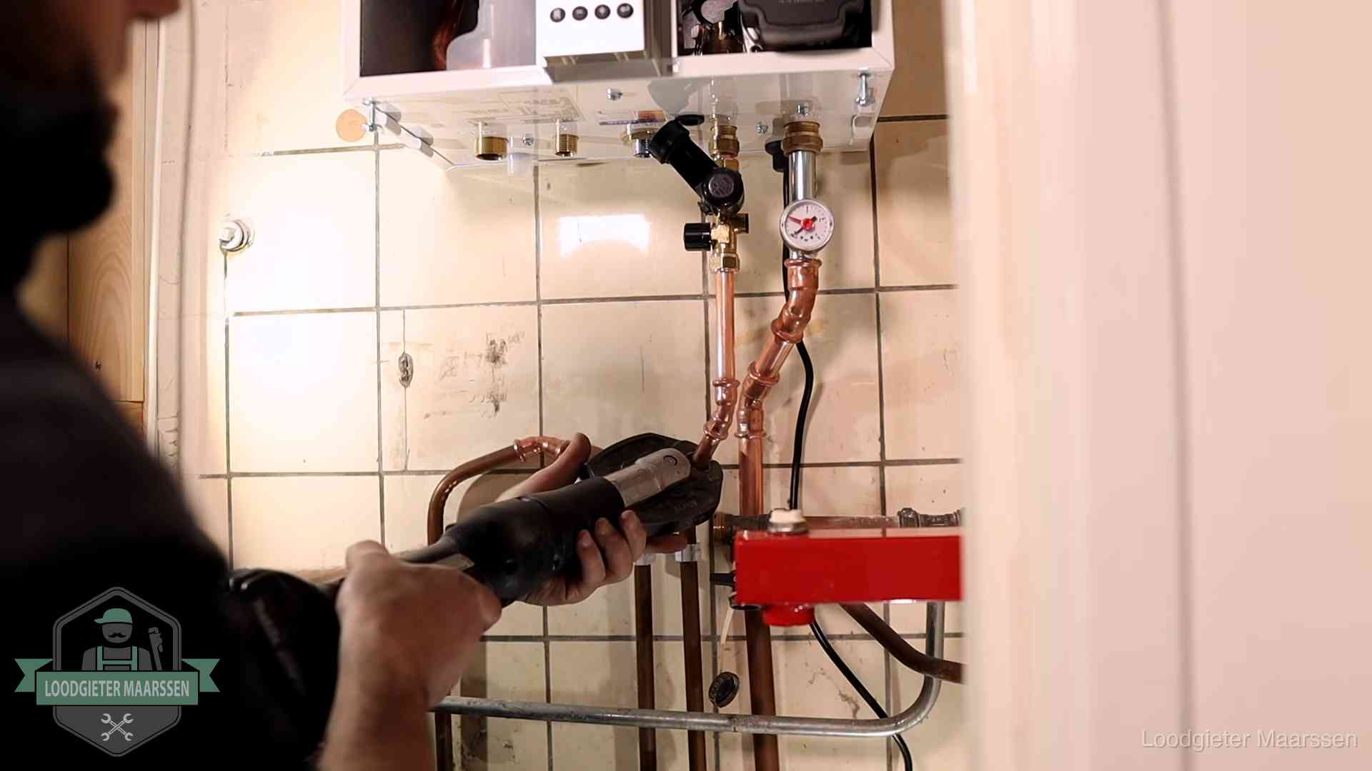 Monteur werkt aan de leidingen onder een cv-ketel in Maarssen