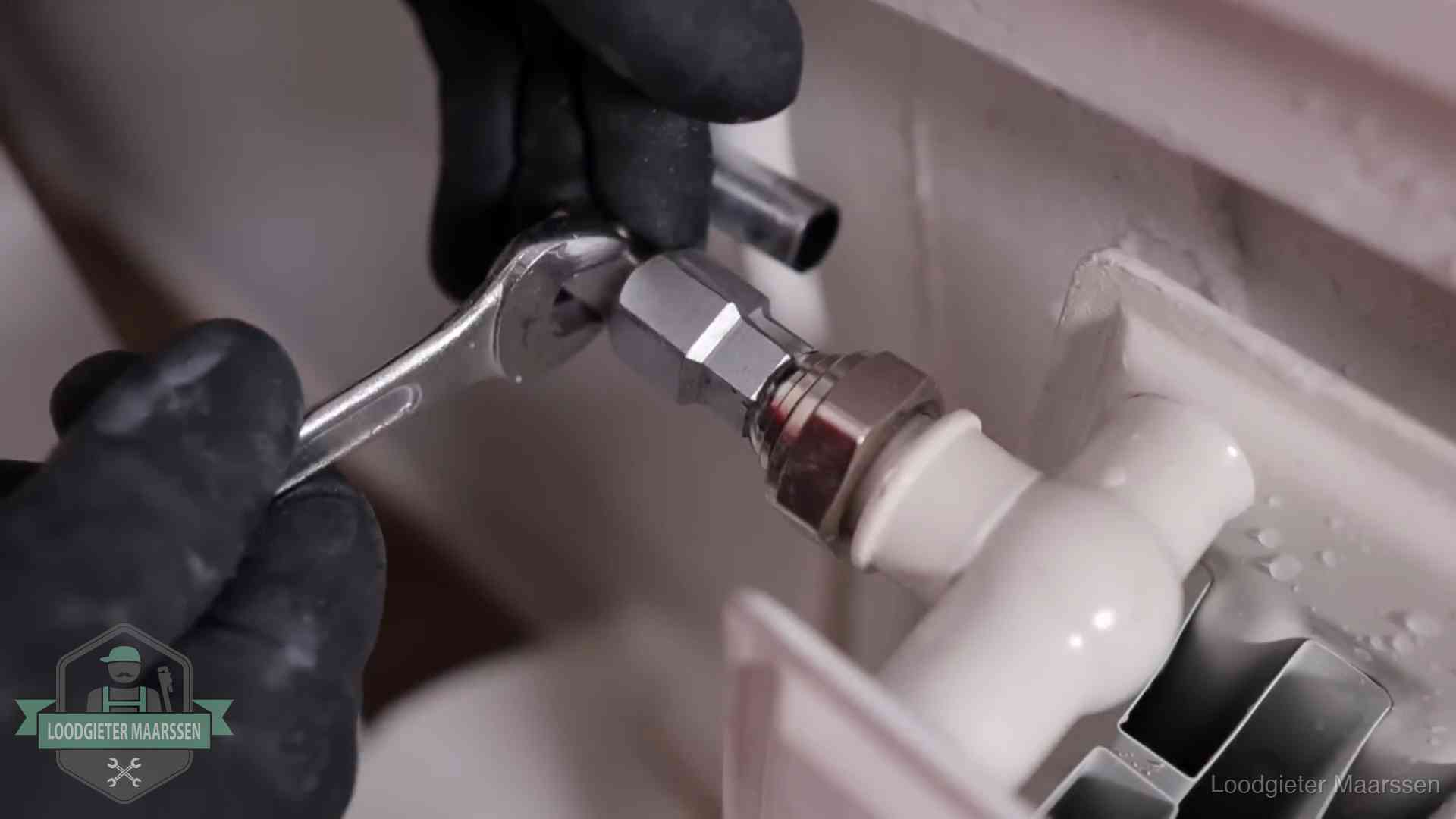 Steeksleutel draait een wartelkoppeling op een radiatorkraan aan in Maarssen