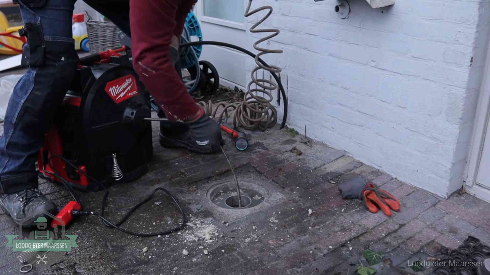Spiraalmachine bij een ontstoppingsputje in de bestrating in Maarssen