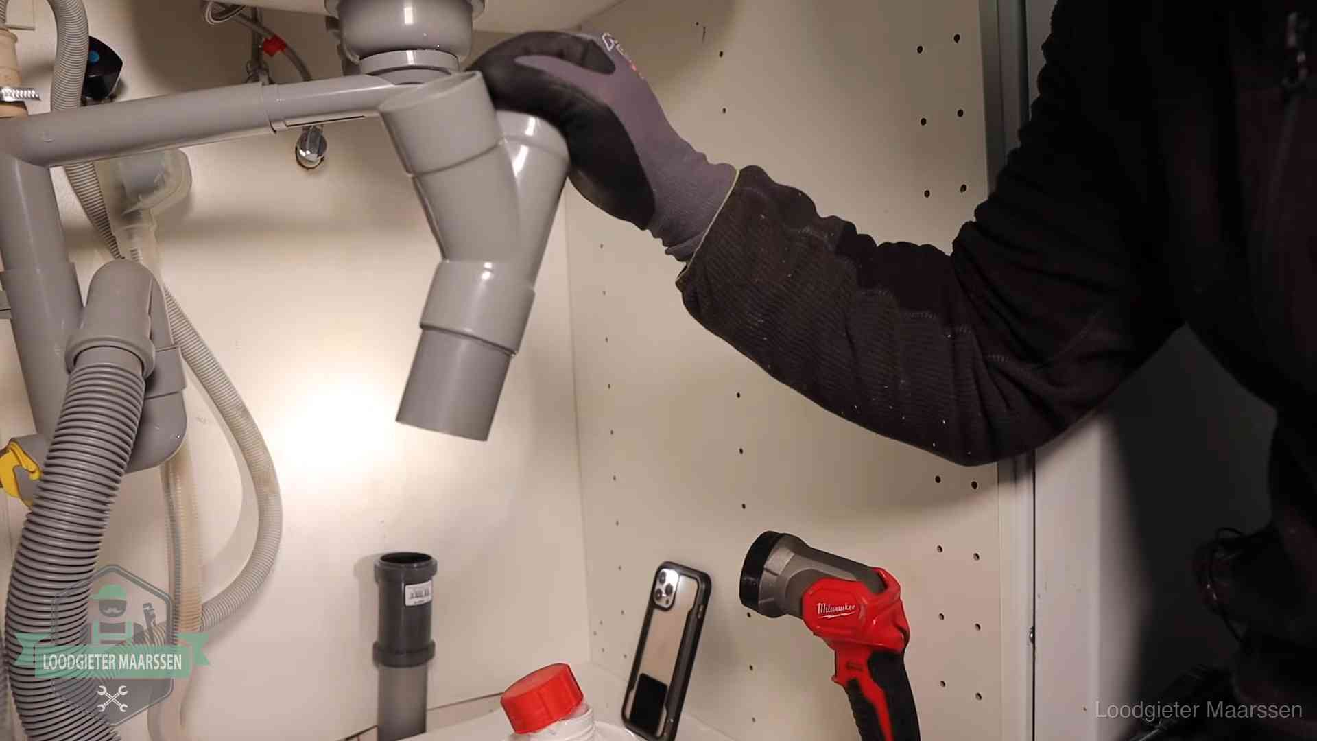 Loodgieter demonteert het sifon- en afvoerwerk onder een gootsteen in Maarssen bij stankklachten