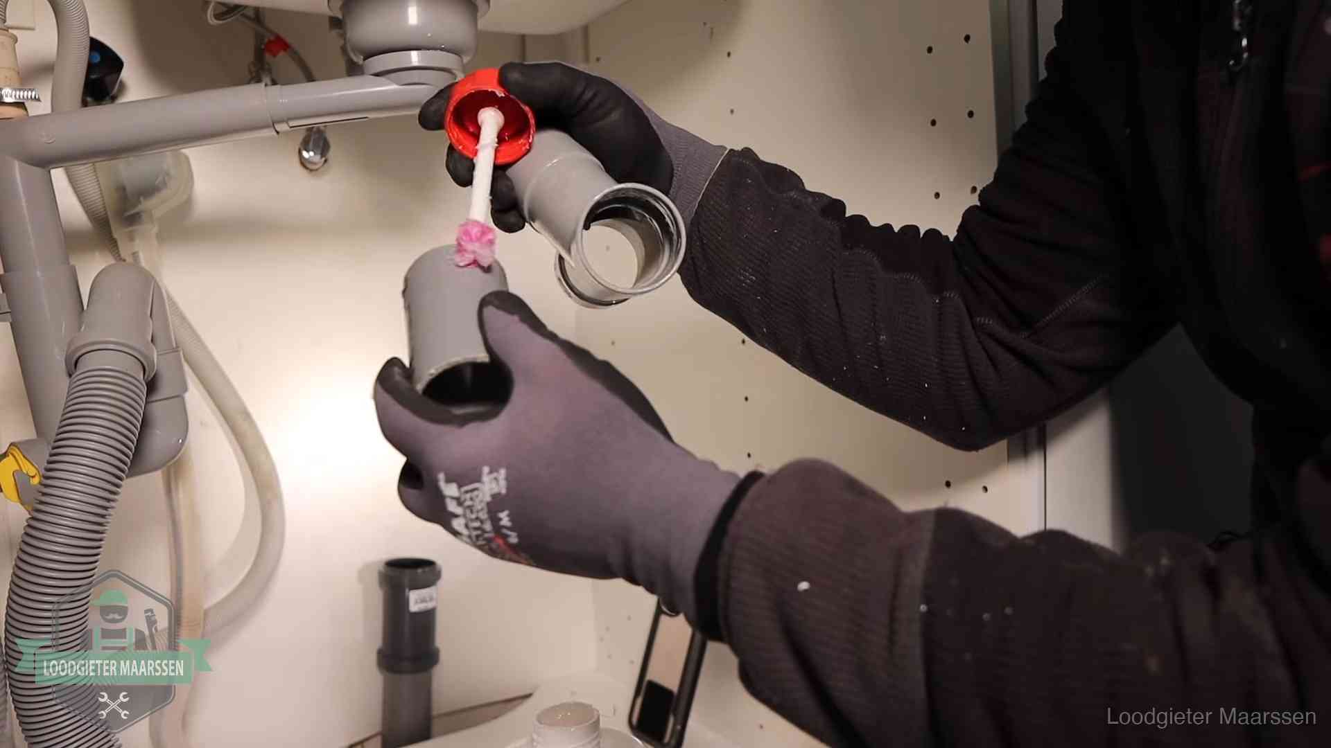 Loodgieter demonteert en reinigt de sifon onder een keukenkast in Maarssen