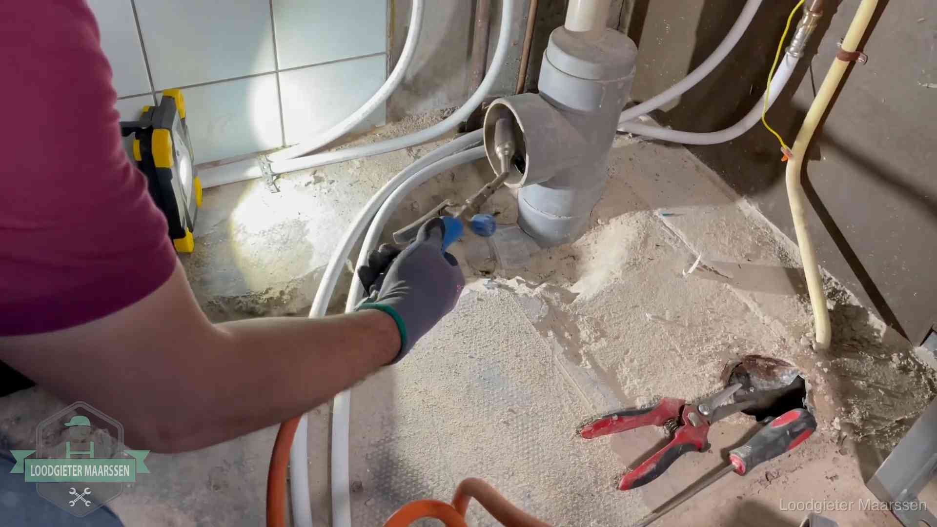 Loodgieter werkt aan leidingen bij een pvc-standleiding in een appartement in Maarssen