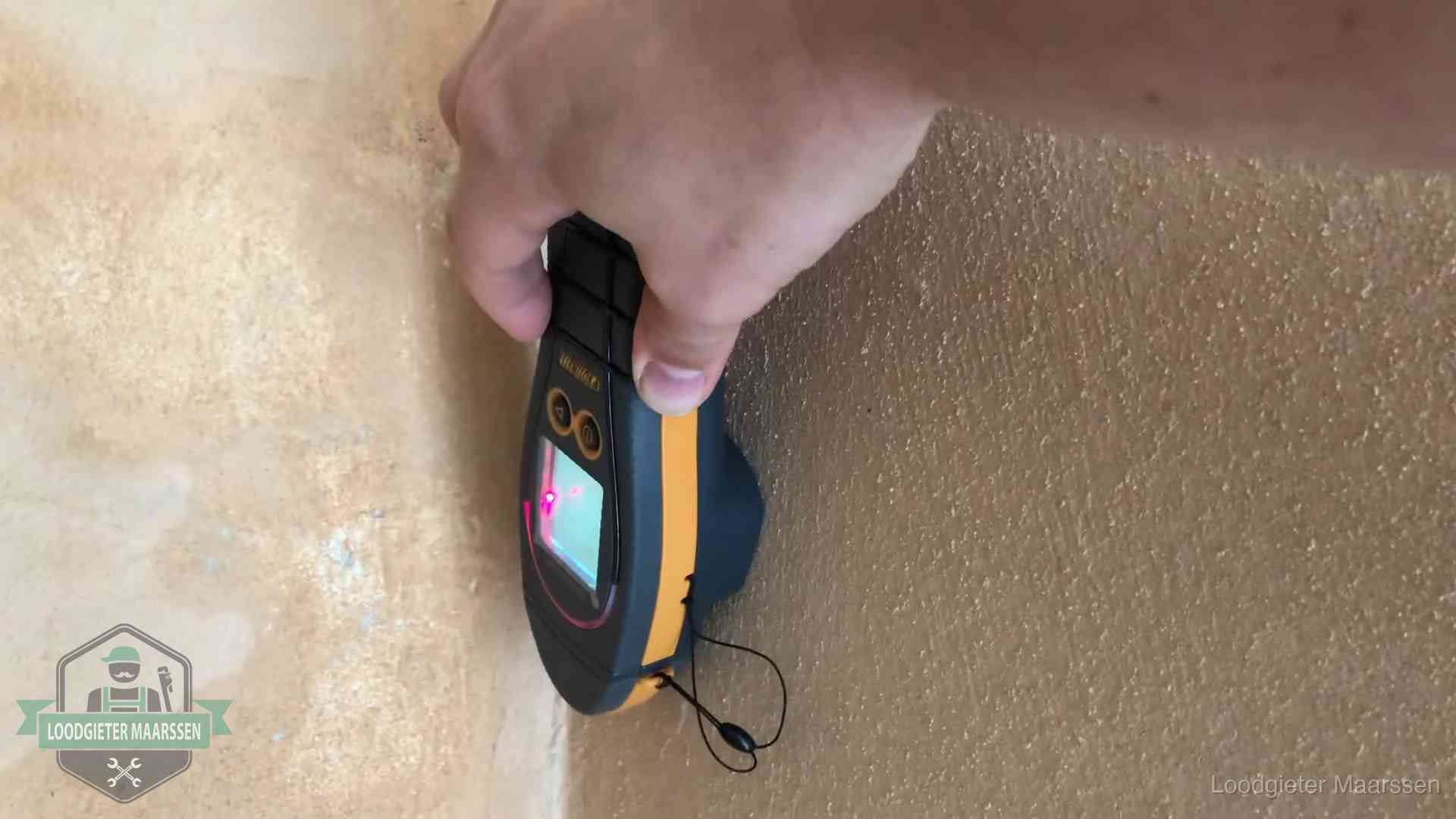 Daklekkage opsporen zonder hakwerk in Maarssen Vochtmeter tegen een muur met vochtplekken tijdens het opsporen van een daklekkage in Maarssen